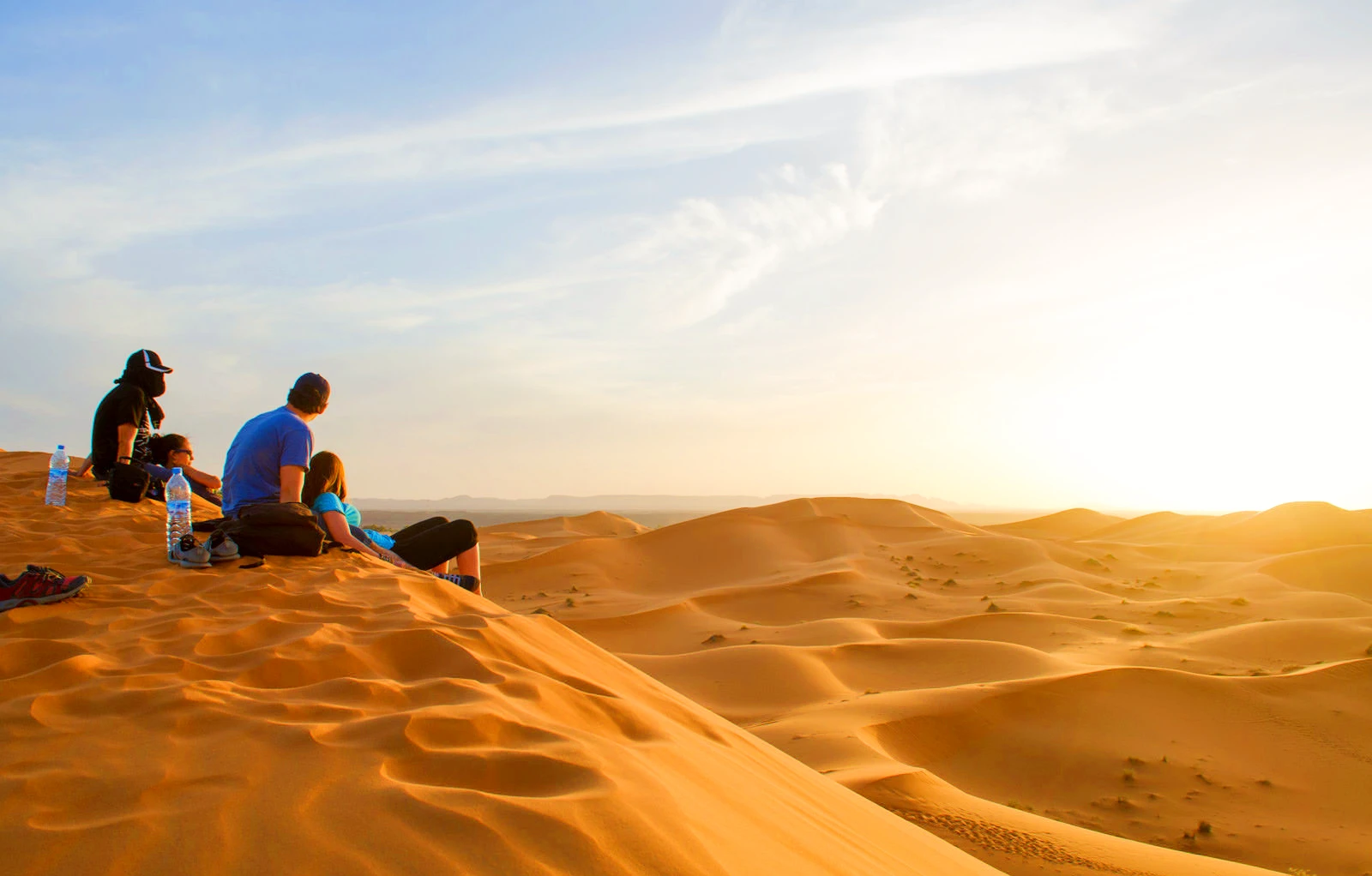 Two couples watching sunrise in the Sahara Desert in Morocco